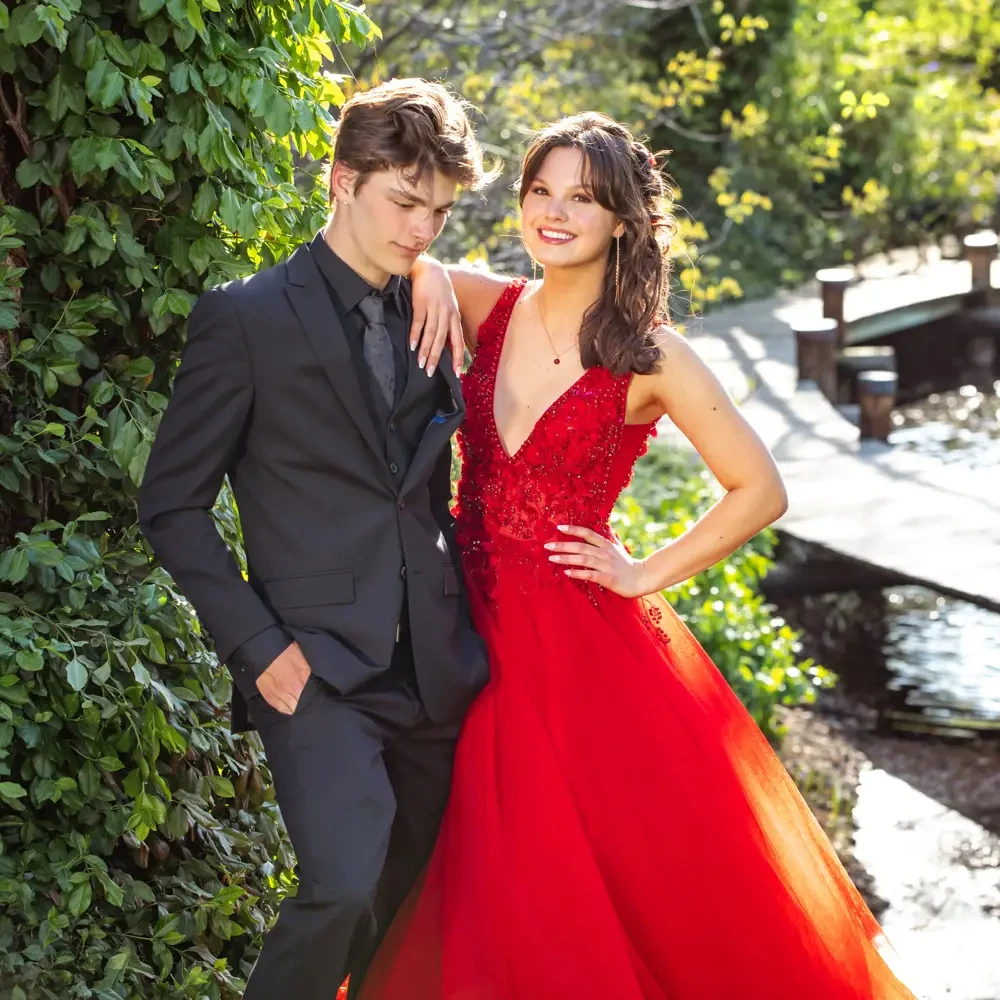 Сouple wearing a red gown and a black suit